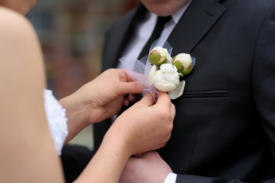 Bride adjusting groom's boutonniere